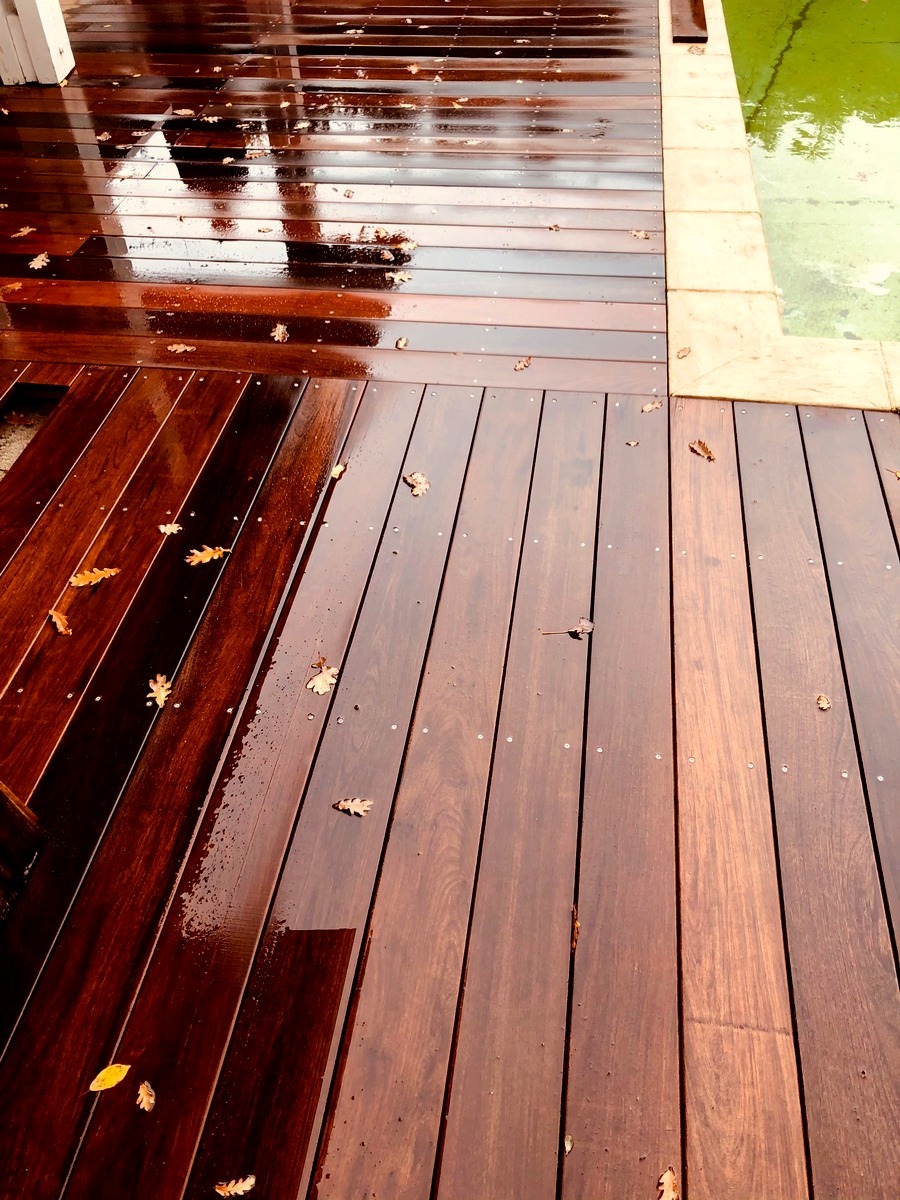 DECKiBOIS Terrasse en bois exotique ipé 21 x 145 mm affleurant une margelle en pierre avec un changement de sens des lames ( photo prise sous la pluie )