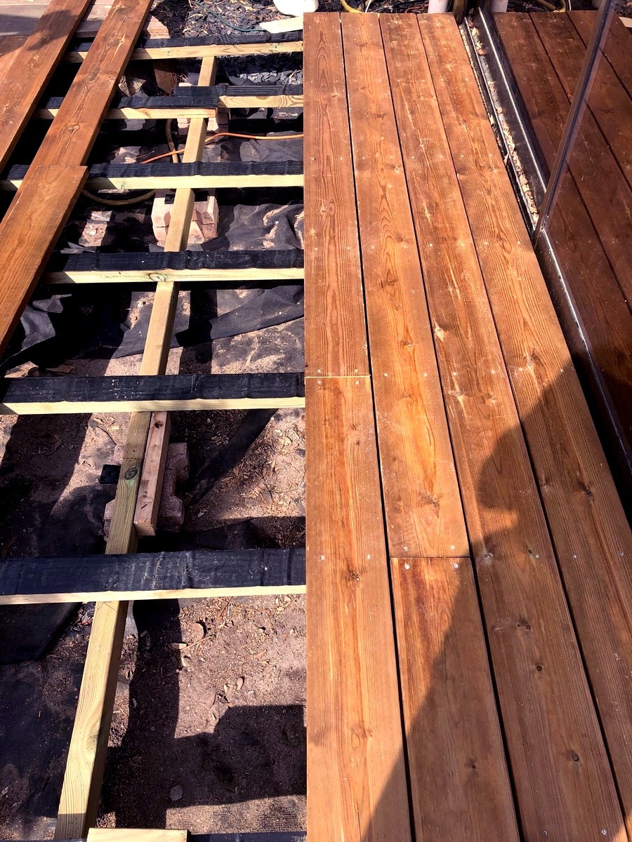 Lames de terrasse en pin du nord choix US en cours d'installation